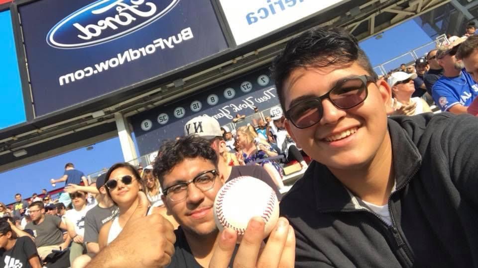 Kids in Seats guests smiling with a baseball at a Yankees game